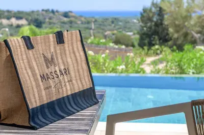 a bag sitting on a chair next to a pool at Massari Hills Villa 9 in Malona Village