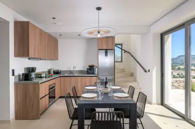 a dining room with a table and chairs in a kitchen at Massari Hills Villa 9 in Malona Village