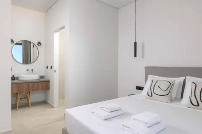 a white bedroom with a large bed and a sink at Massari Hills Villa 9 in Malona Village