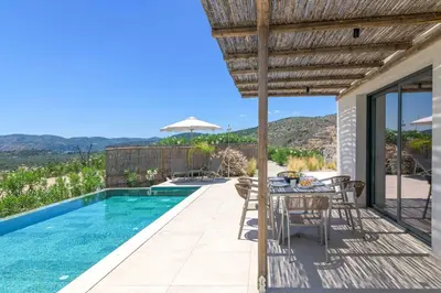 a villa with a swimming pool with a table and chairs at Massari Hills Villa 9 in Malona Village