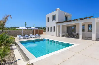 a villa with a swimming pool in front of a house at Villa Panaxia Akte in Theologos