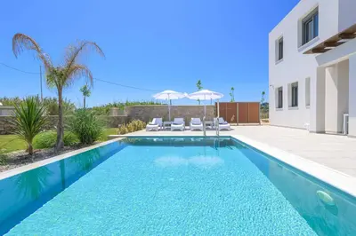 a swimming pool in front of a house at Villa Panaxia Akte in Theologos