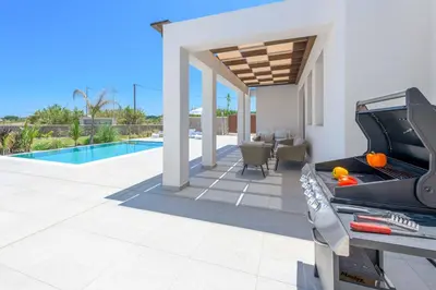 a house with a pool and a grill on a patio at Villa Panaxia Akte in Theologos