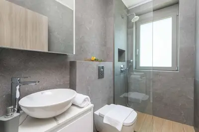 a bathroom with a white sink and a shower at Villa Panaxia Akte in Theologos