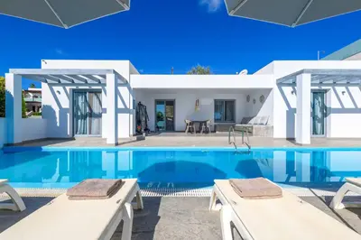 a villa with a swimming pool and a house at Villa Pefko in Gennadi