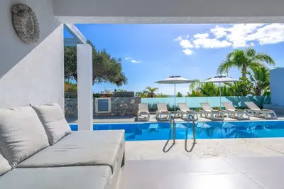 a living room with a couch and a swimming pool at Villa Pefko in Gennadi