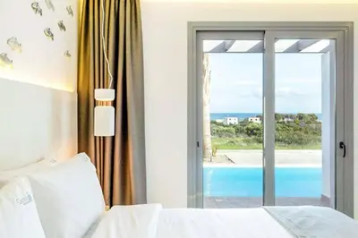 a bedroom with a bed and a view of the ocean at Villa Damaskina in Gennadi