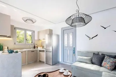 a living room with a couch and a kitchen with birds on the wall at Villa Damaskina in Gennadi