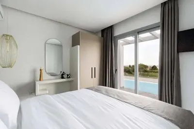 a bedroom with a large white bed and a window at Villa Damaskina in Gennadi