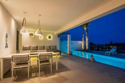 a living room with a table and chairs and a patio at Villa Damaskina in Gennadi