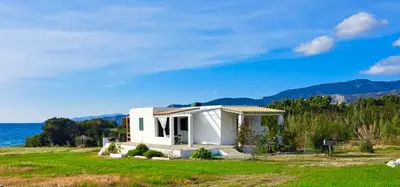a small white house with a view of the ocean at Charming Cottage on the sea turtle beach in Apolakkiá