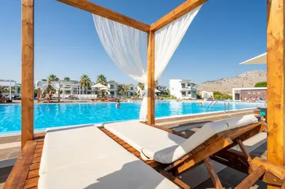 a pair of lounge chairs next to a swimming pool at Kamari Beach in Lardos
