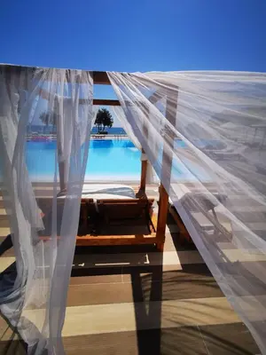 a bedroom with a bed with a mosquito net at Kamari Beach in Lardos