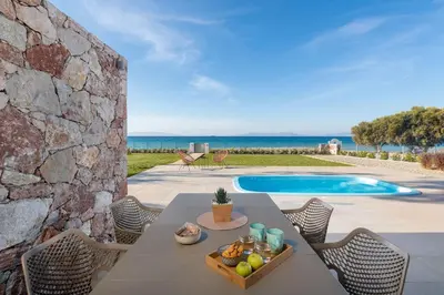 a patio with a table and chairs and a swimming pool at KYRA beachfront house in Theologos Rhodes in Theologos
