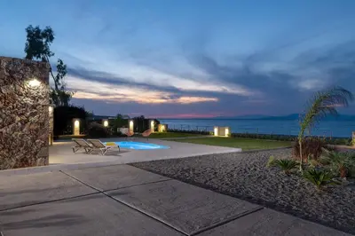 a patio with a view of the ocean at night at KYRA beachfront house in Theologos Rhodes in Theologos