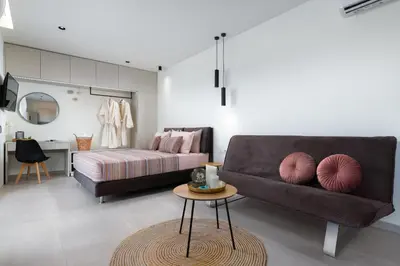 a bedroom with a bed and a couch and a table at KYRA beachfront house in Theologos Rhodes in Theologos