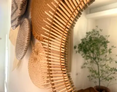 a large wicker mirror hanging on a wall at Villa Paradisos Archangelos in Archangelos