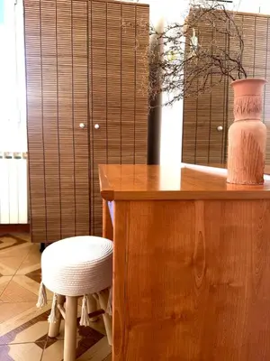 a wooden table with a stool and a vase and a chair at Villa Paradisos Archangelos in Archangelos