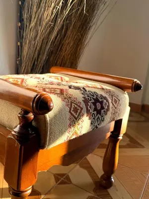 a wooden chair with a rug on top of it at Villa Paradisos Archangelos in Archangelos