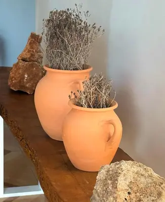 two orange vases with plants in them on a table at Villa Paradisos Archangelos in Archangelos