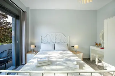 a bedroom with a large white bed with two lamps at E&A luxury apartment with sea view in Rhodes Town