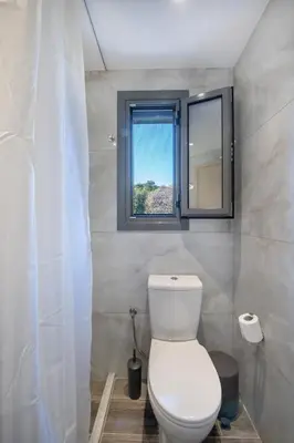 a white toilet in a bathroom with a window at E&A luxury apartment with sea view in Rhodes Town