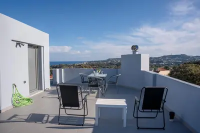 a patio with a table and chairs on a balcony at E&A luxury apartment with sea view in Rhodes Town