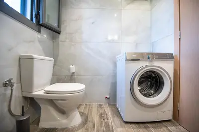 a bathroom with a toilet and a washing machine at E&A luxury apartment with sea view in Rhodes Town