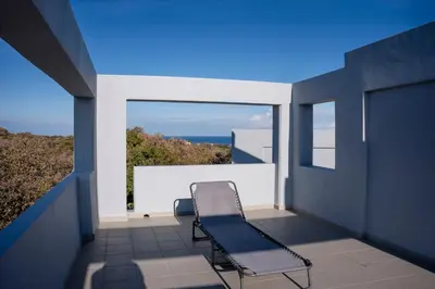 a chair on a balcony with a view of the ocean at E&A luxury apartment with sea view in Rhodes Town