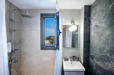 a bathroom with a sink and a shower with a window at E&A luxury apartment with sea view in Rhodes Town