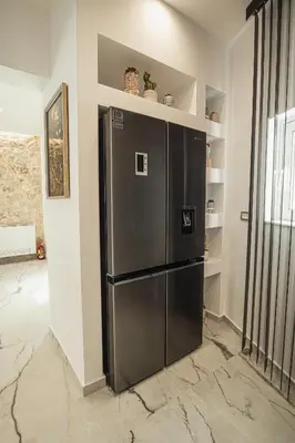 a large black refrigerator in a room with shelves at Lofos Inn Villa Luxury in Kalithies
