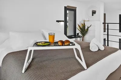 a tray of food on top of a bed at San Marino Luxury Suites #3 in Asgourou