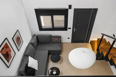 a living room with a gray couch and a window at San Marino Luxury Suites #3 in Asgourou