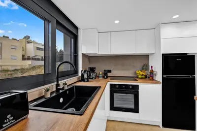 a kitchen with a black sink and a window at San Marino Luxury Suites #3 in Asgourou