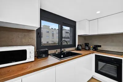 a kitchen with a microwave and a sink and a window at San Marino Luxury Suites #3 in Asgourou