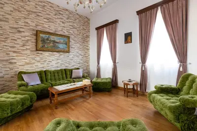 a living room with green furniture and a brick wall at Casa Medievale in Rhodes Town