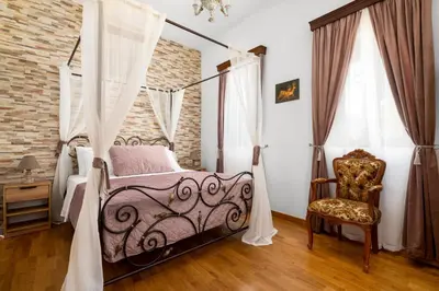 a bedroom with a canopy bed and a chair at Casa Medievale in Rhodes Town