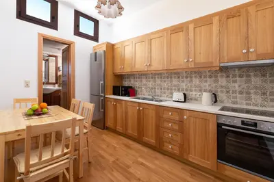 a kitchen with wooden cabinets and a wooden table at Casa Medievale in Rhodes Town
