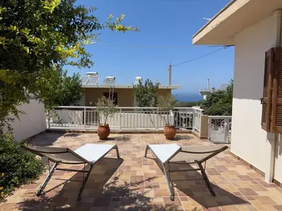 a patio with two chairs and a table at Maison authentique avec grande terrasse in Kritinía