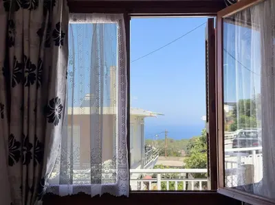 a window with a view of a building at Maison authentique avec grande terrasse in Kritinía