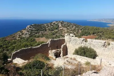 an old castle on top of a hill next to the ocean at Maison authentique avec grande terrasse in Kritinía