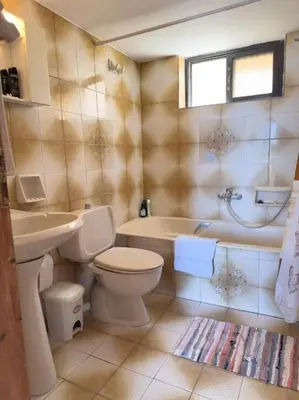a bathroom with a toilet and a tub and a sink at Maison authentique avec grande terrasse in Kritinía