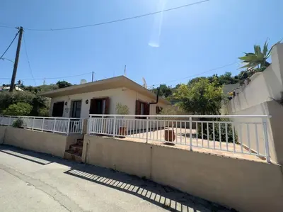 a house with a white fence in front of it at Maison authentique avec grande terrasse in Kritinía