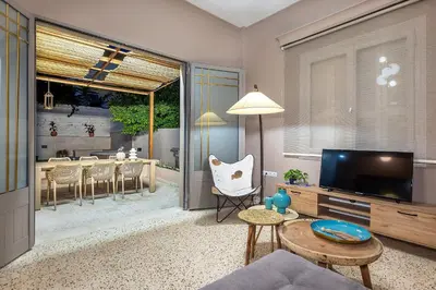 a living room with a television and a dining room at Lefka Home in Rhodes Town
