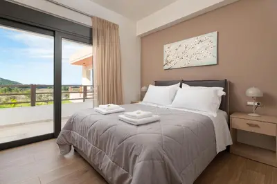 a bedroom with a bed and a large window at Elias' Rest Villa in Pastida