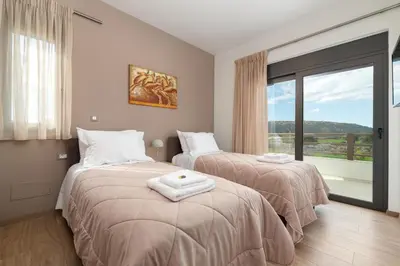 a bedroom with two beds and a large window at Elias' Rest Villa in Pastida