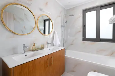 a bathroom with a sink and a mirror and a tub at Elias' Rest Villa in Pastida