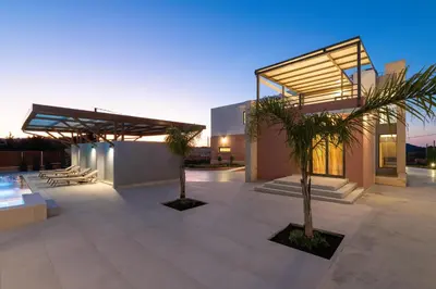 a house with two palm trees in front of it at Elias' Rest Villa in Pastida