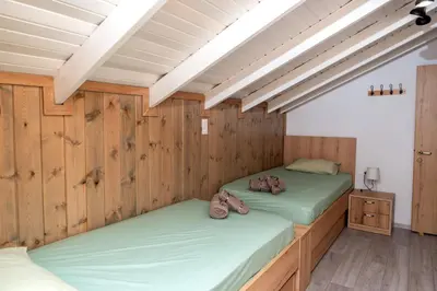 two beds in a room with wooden walls at Giannis House in Rhodes Town