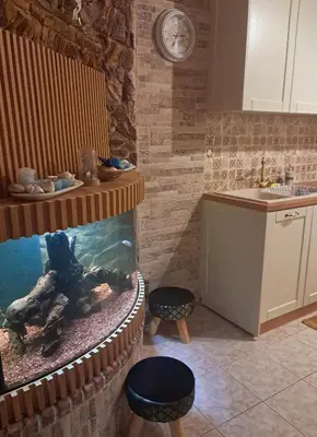 a kitchen with a fish tank and two stools at Giannis House in Rhodes Town